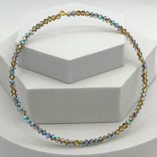 Necklace with multicolored beads on a white stand