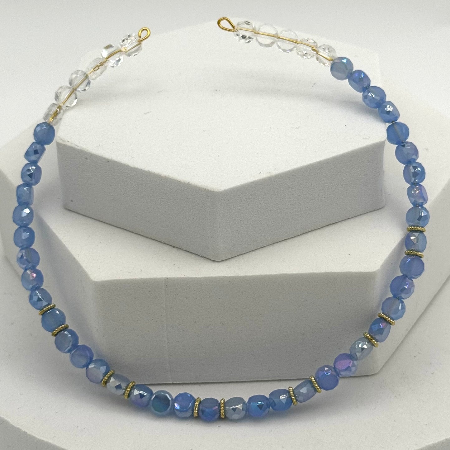 Blue beaded necklace on a white stand