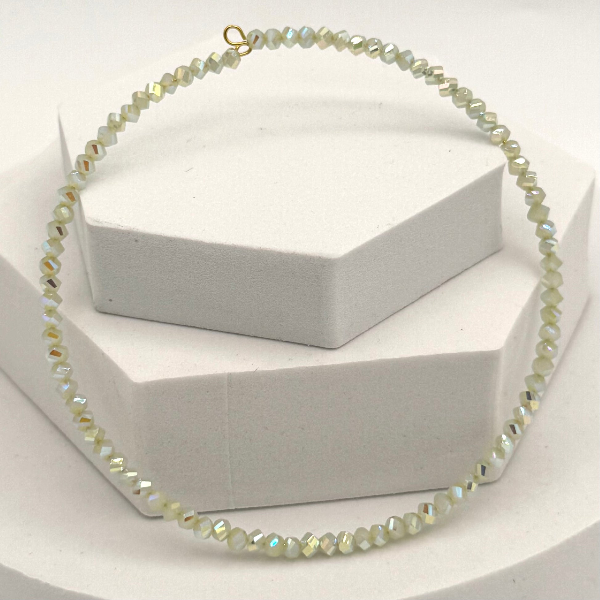 Necklace with small beads on a white stand