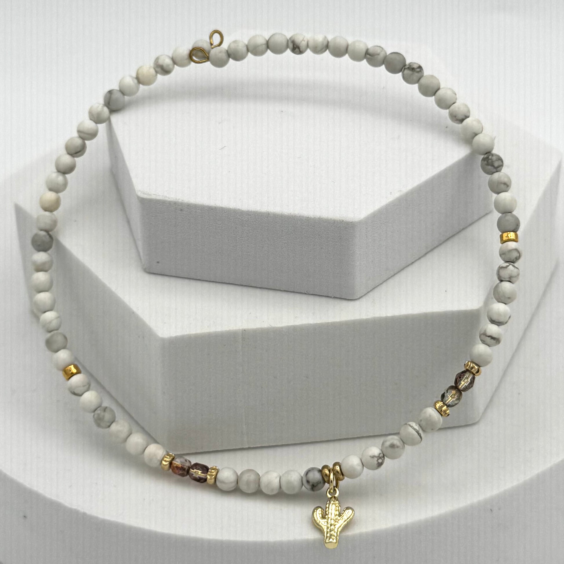 Beaded necklace with a gold charm on a white background