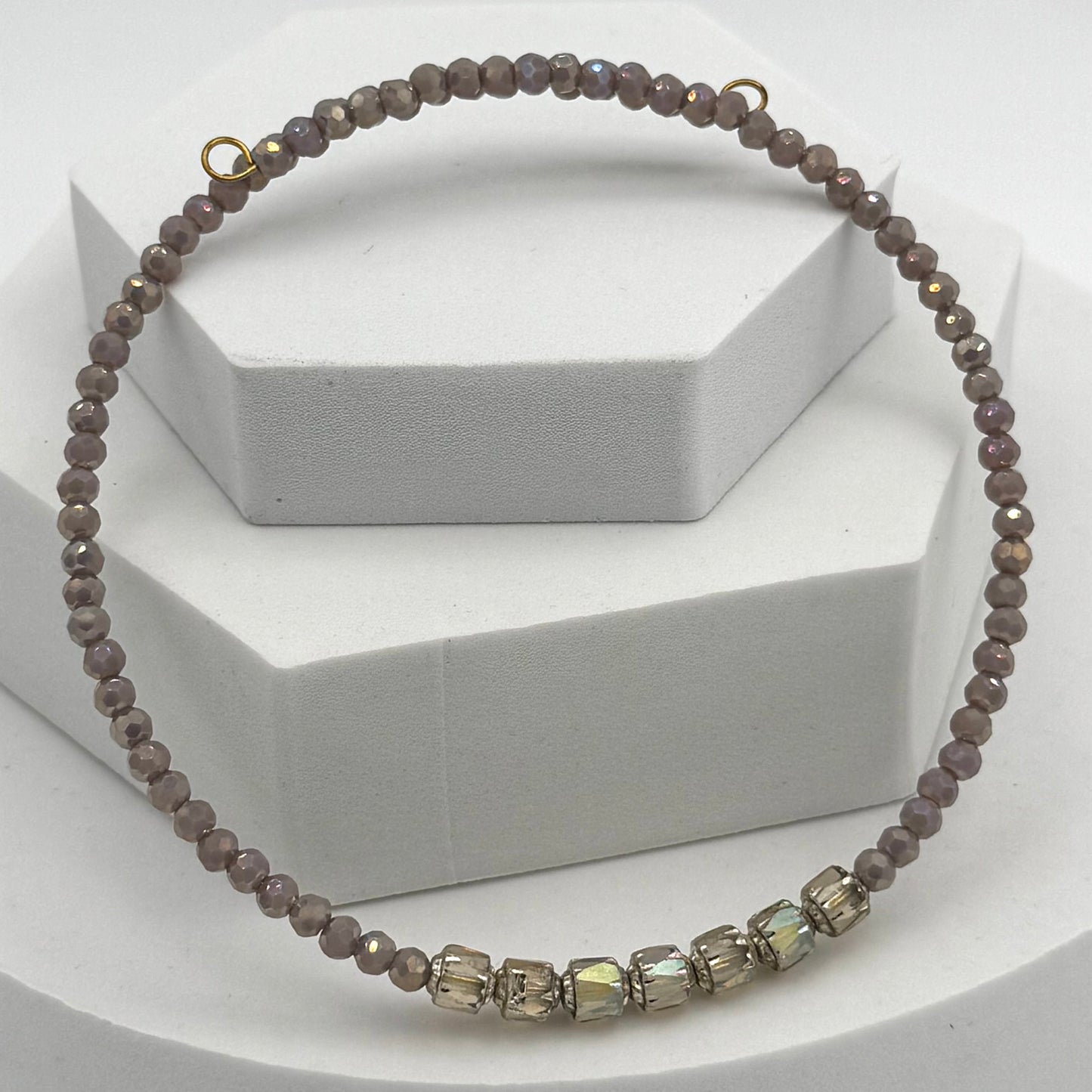 Necklace with brown beads and a gold clasp on a white background