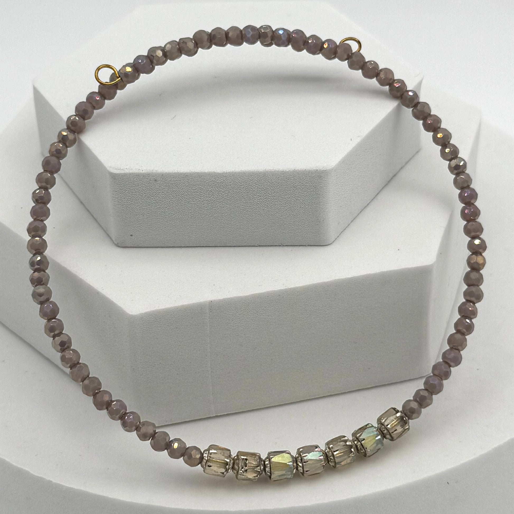 Necklace with brown beads and a gold clasp on a white background