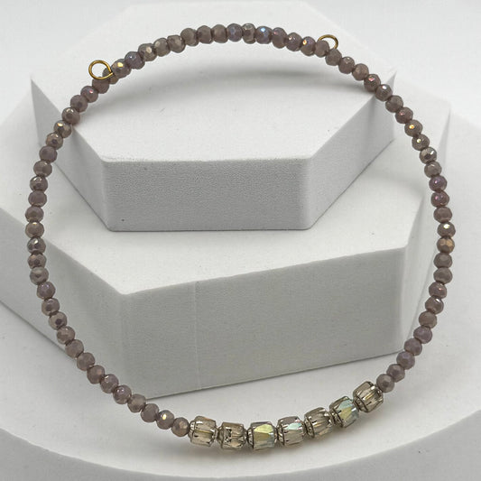Necklace with brown beads and a gold clasp on a white background