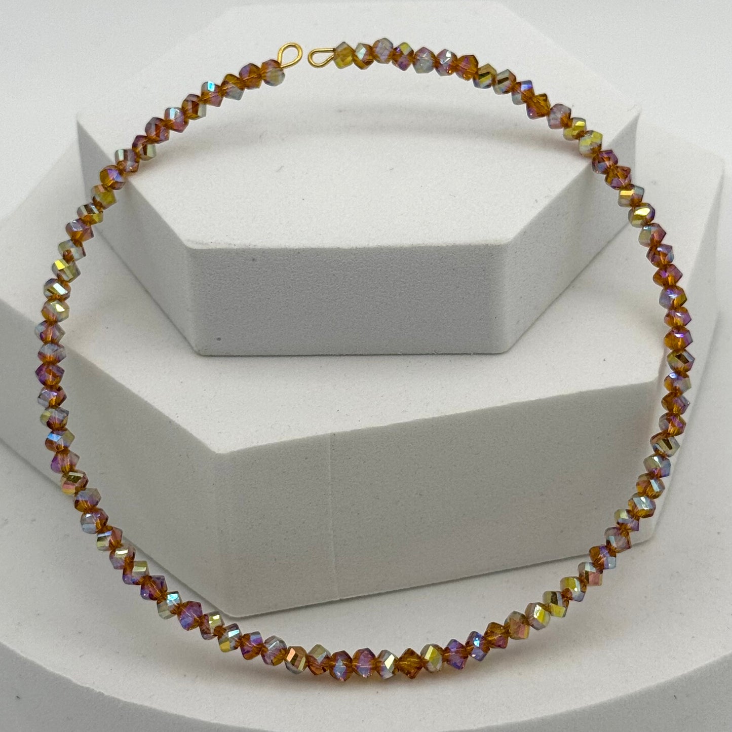 Multicolored beaded necklace on a white stand