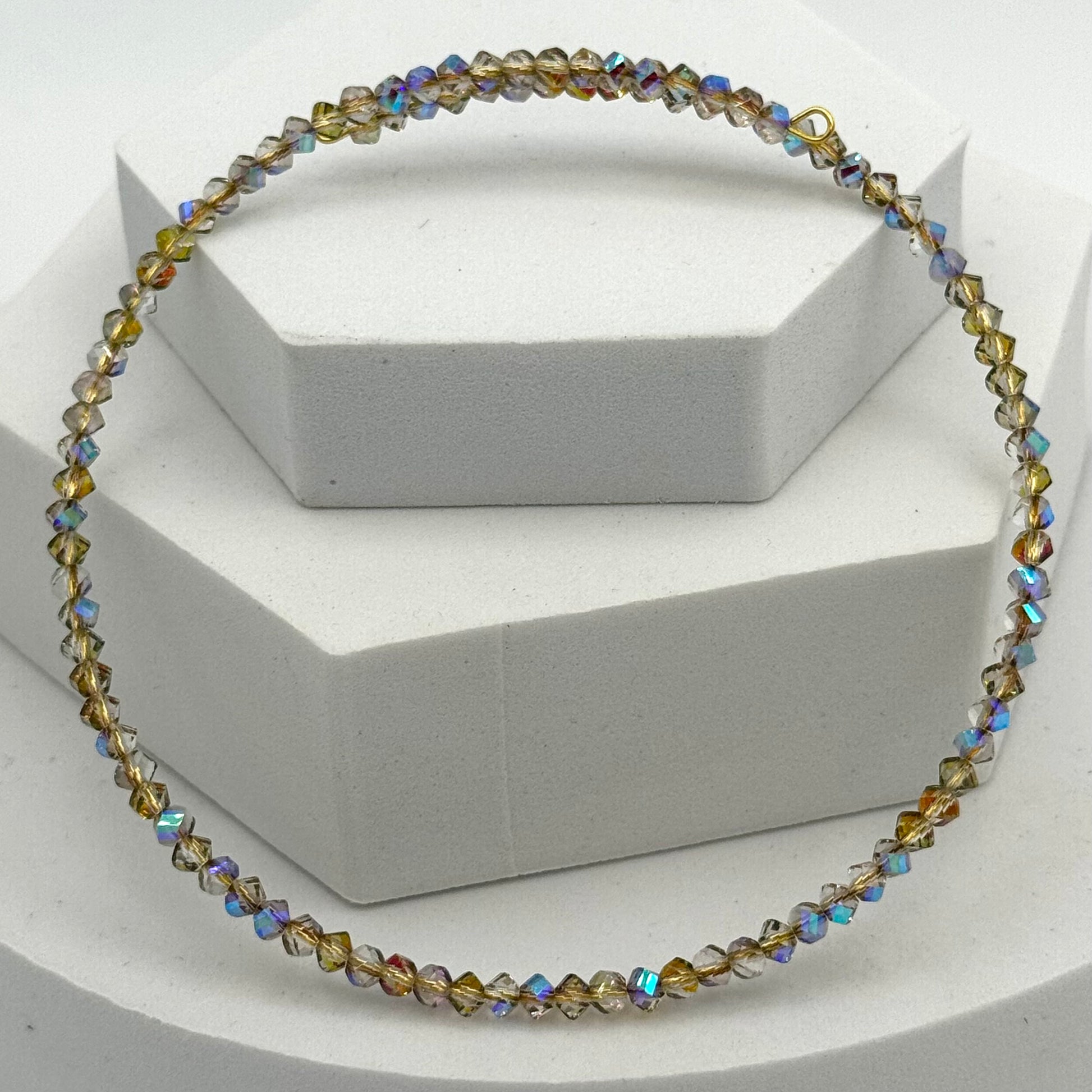 Multicolored beaded necklace on a white stand