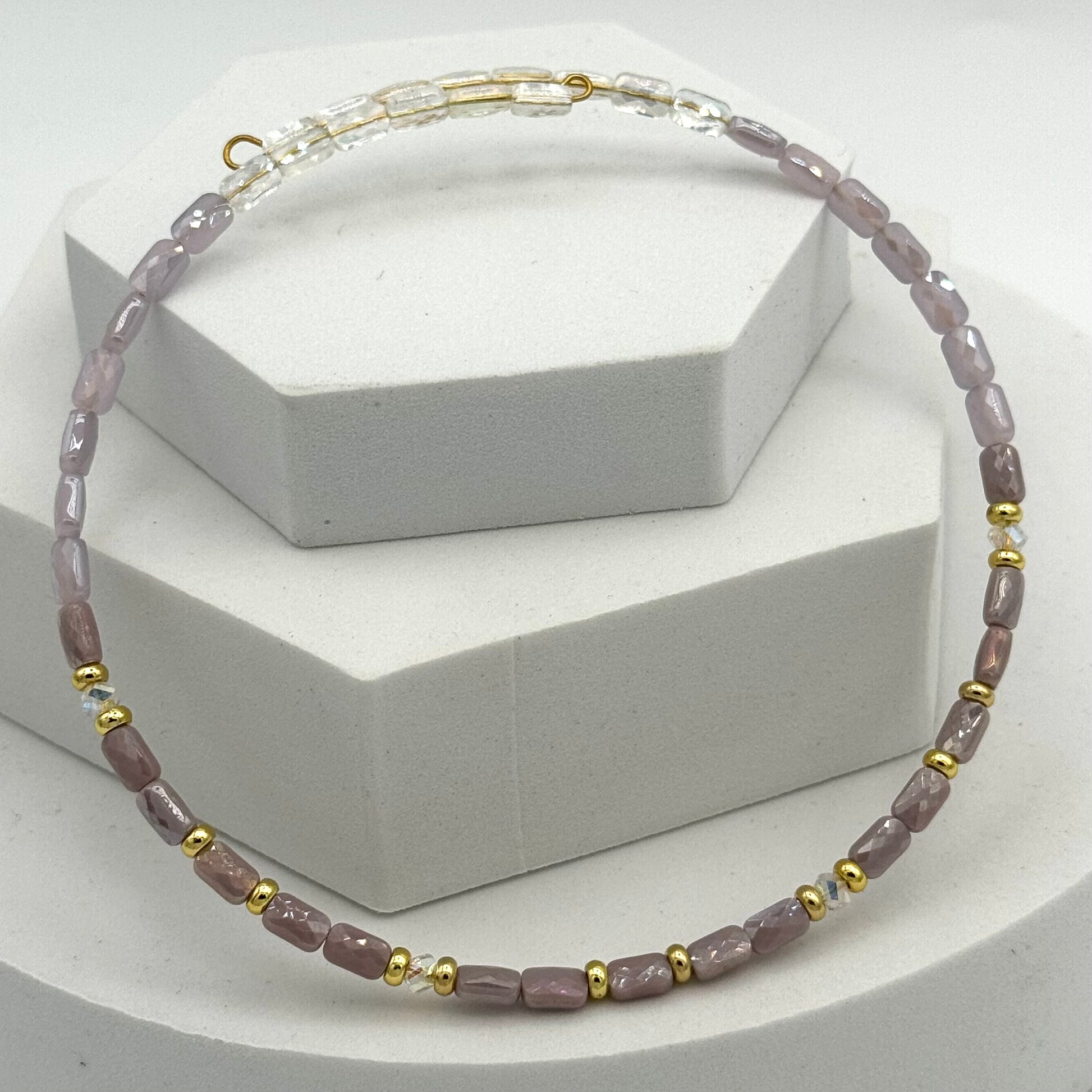 Necklace with pink and gold beads on a white background