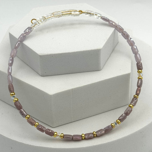 Necklace with pink and gold beads on a white background