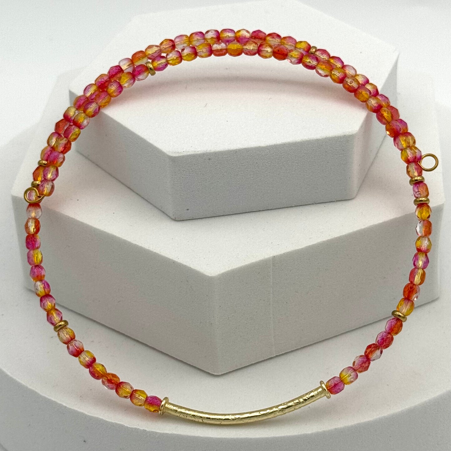 Necklace with multicolored beads and gold clasp on a white background