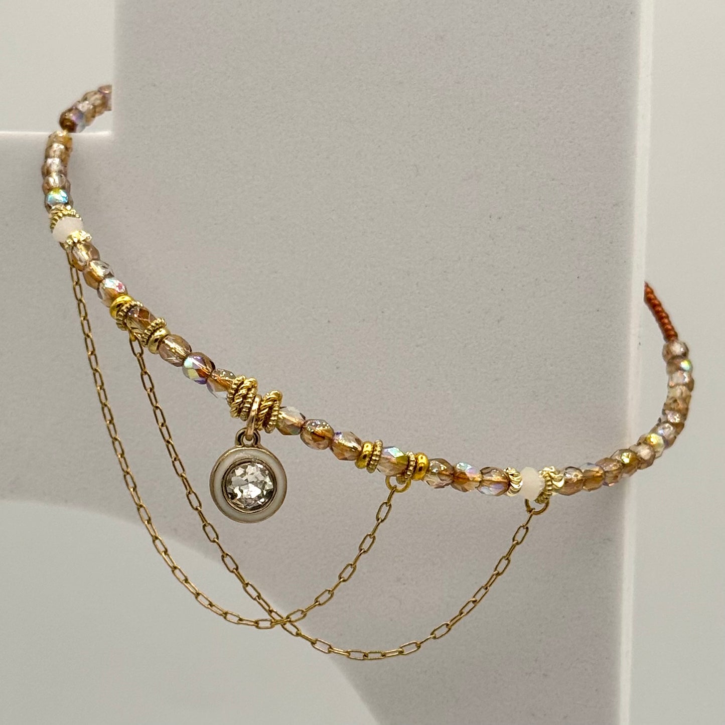 Multistrand beaded necklace with a central pendant on a light gray background