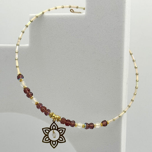 Necklace with beaded chain and decorative pendant on a gray background