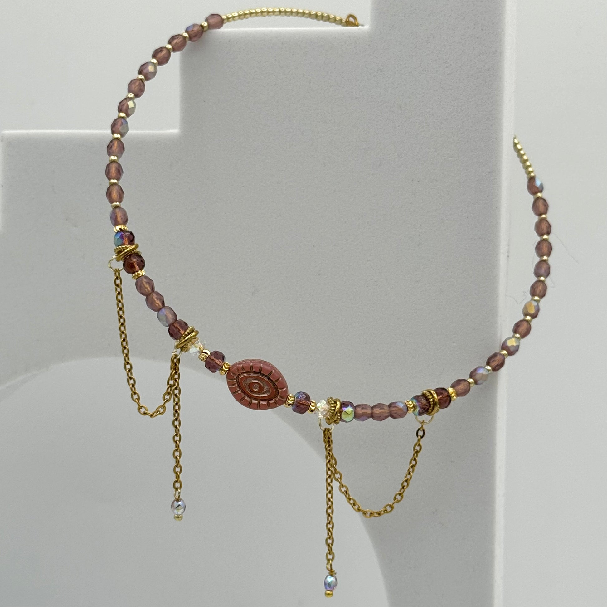 Necklace with brown beads and gold chains on a white background