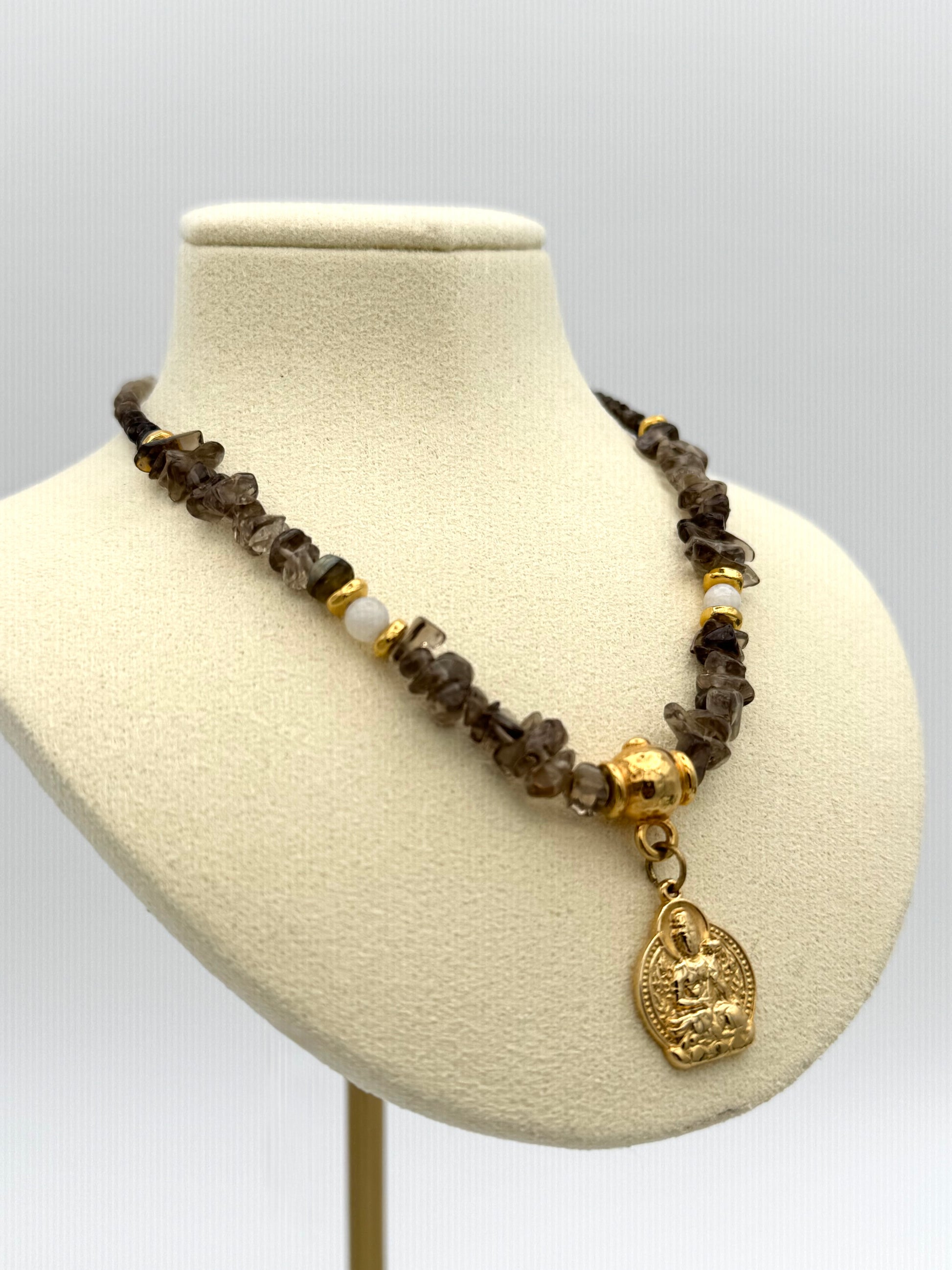 Necklace with brown and gold beads on a mannequin bust against a white background