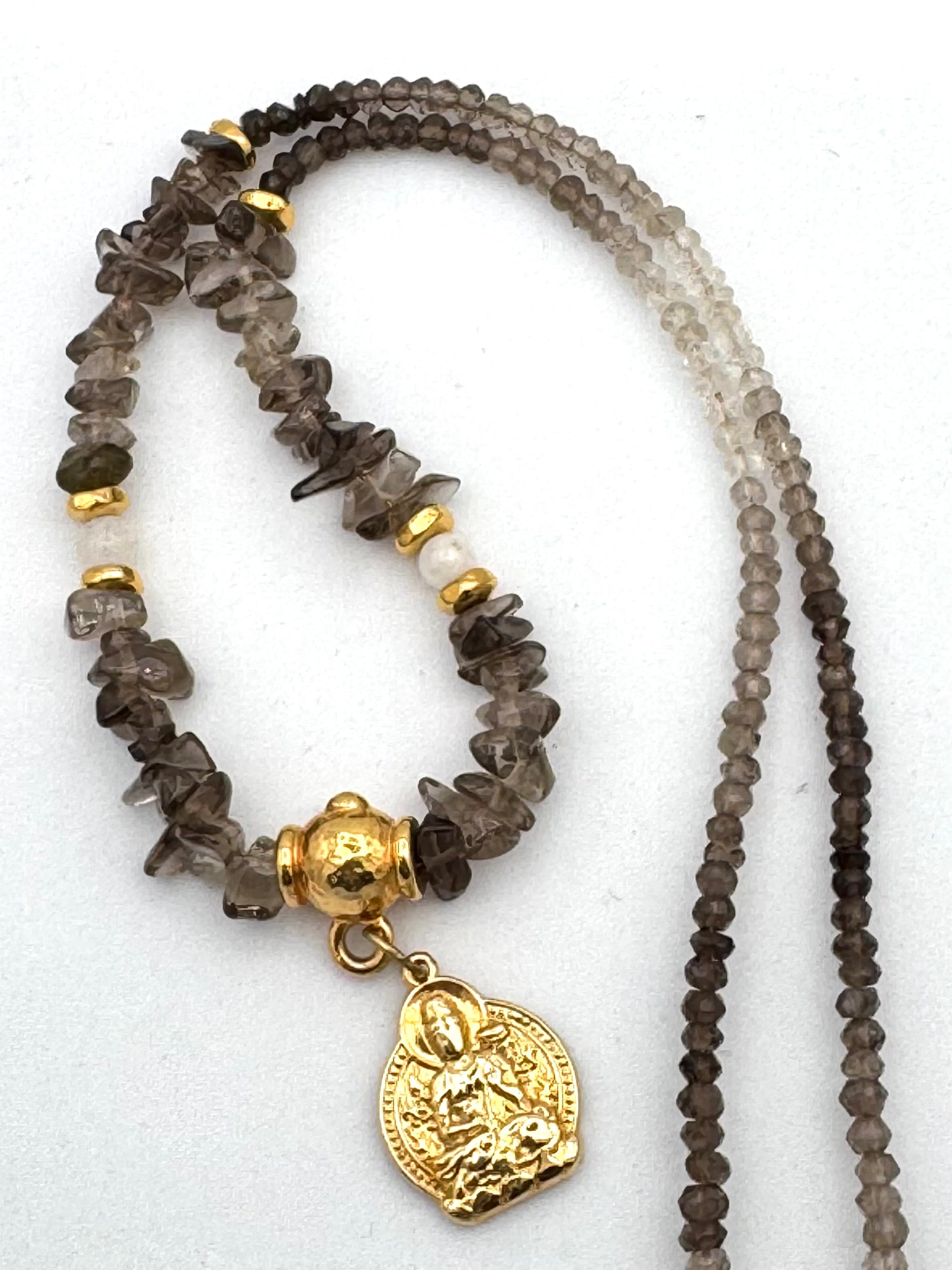 Necklace with brown beads and a gold pendant on a white background