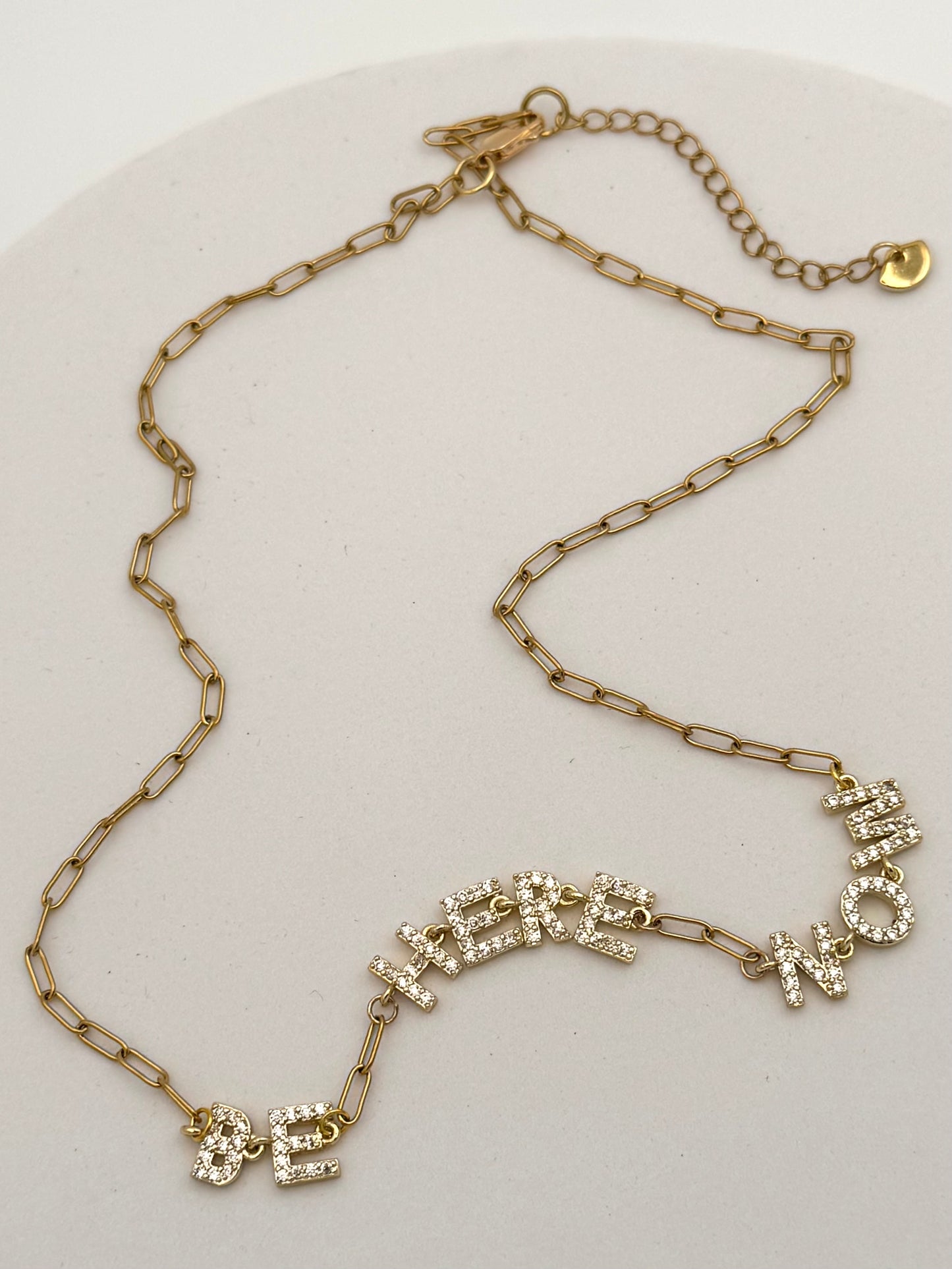 Gold chain necklace with decorative clasp on a white background