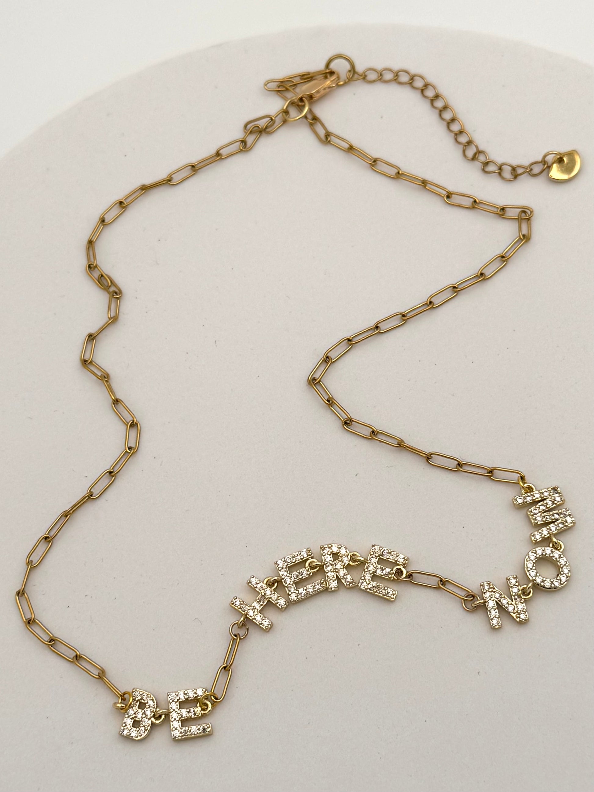 Gold chain necklace with decorative clasp on a white background