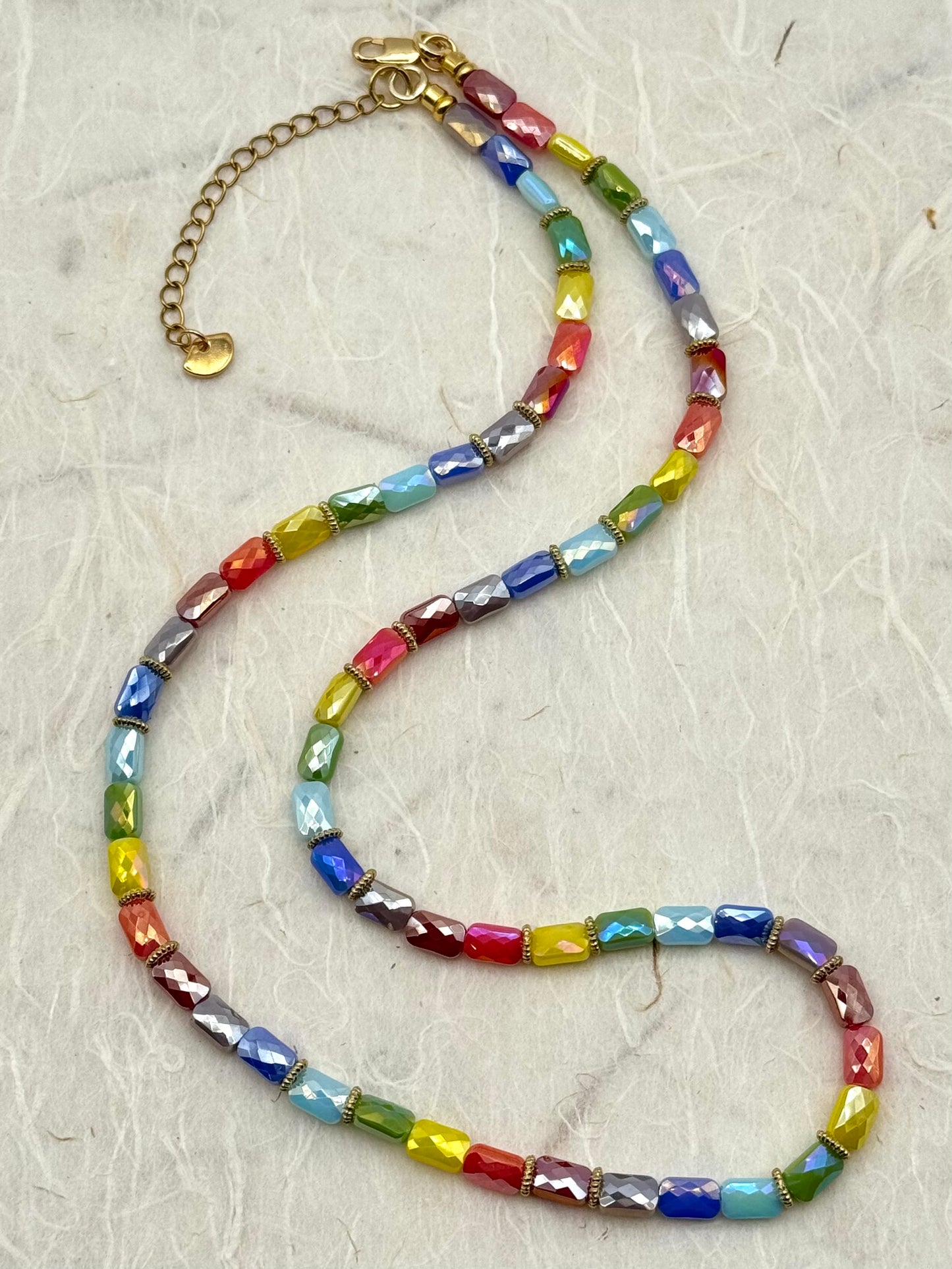 Colorful beaded necklace on a textured gray surface