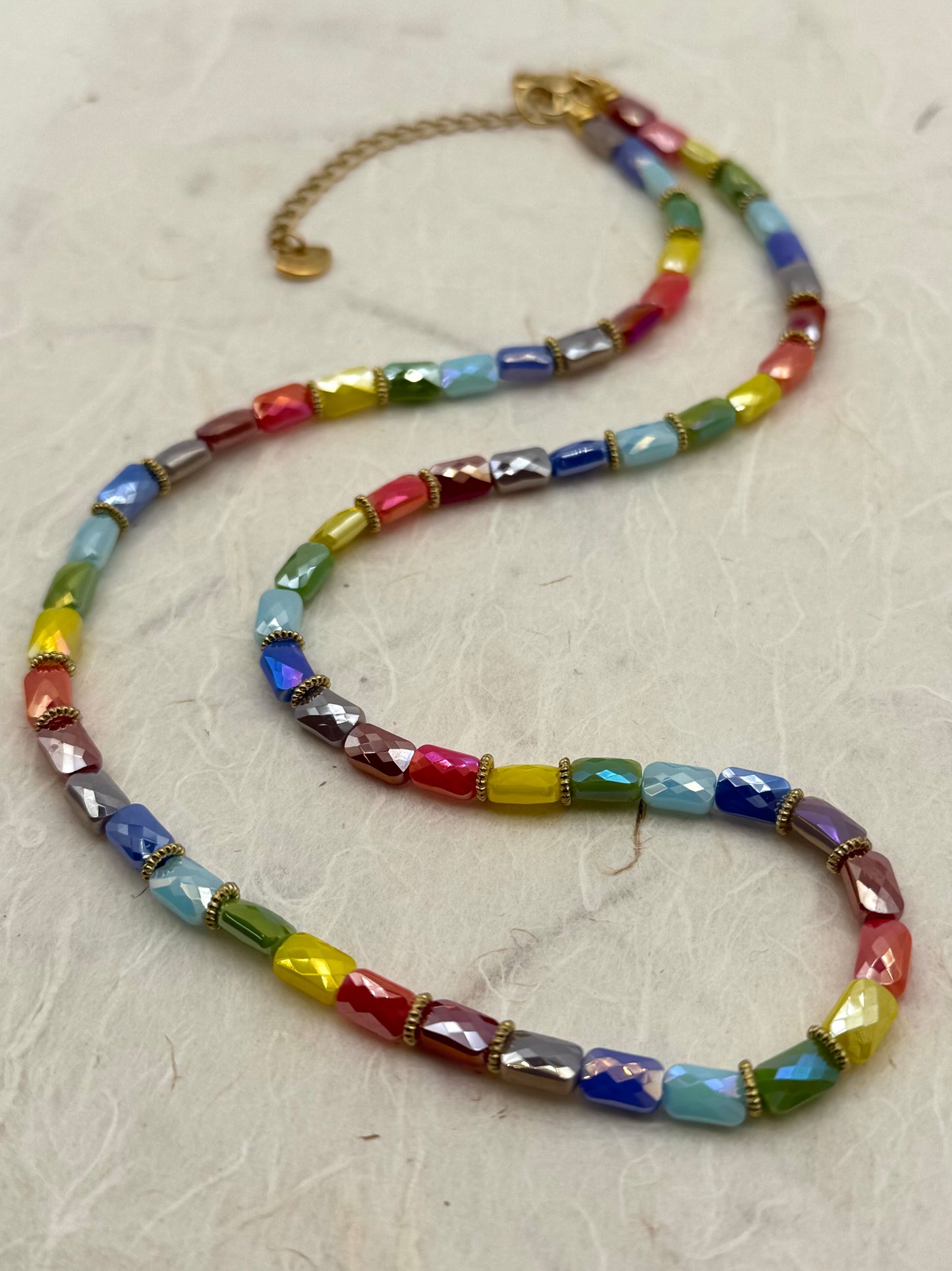 Colorful beaded necklace on a light gray surface