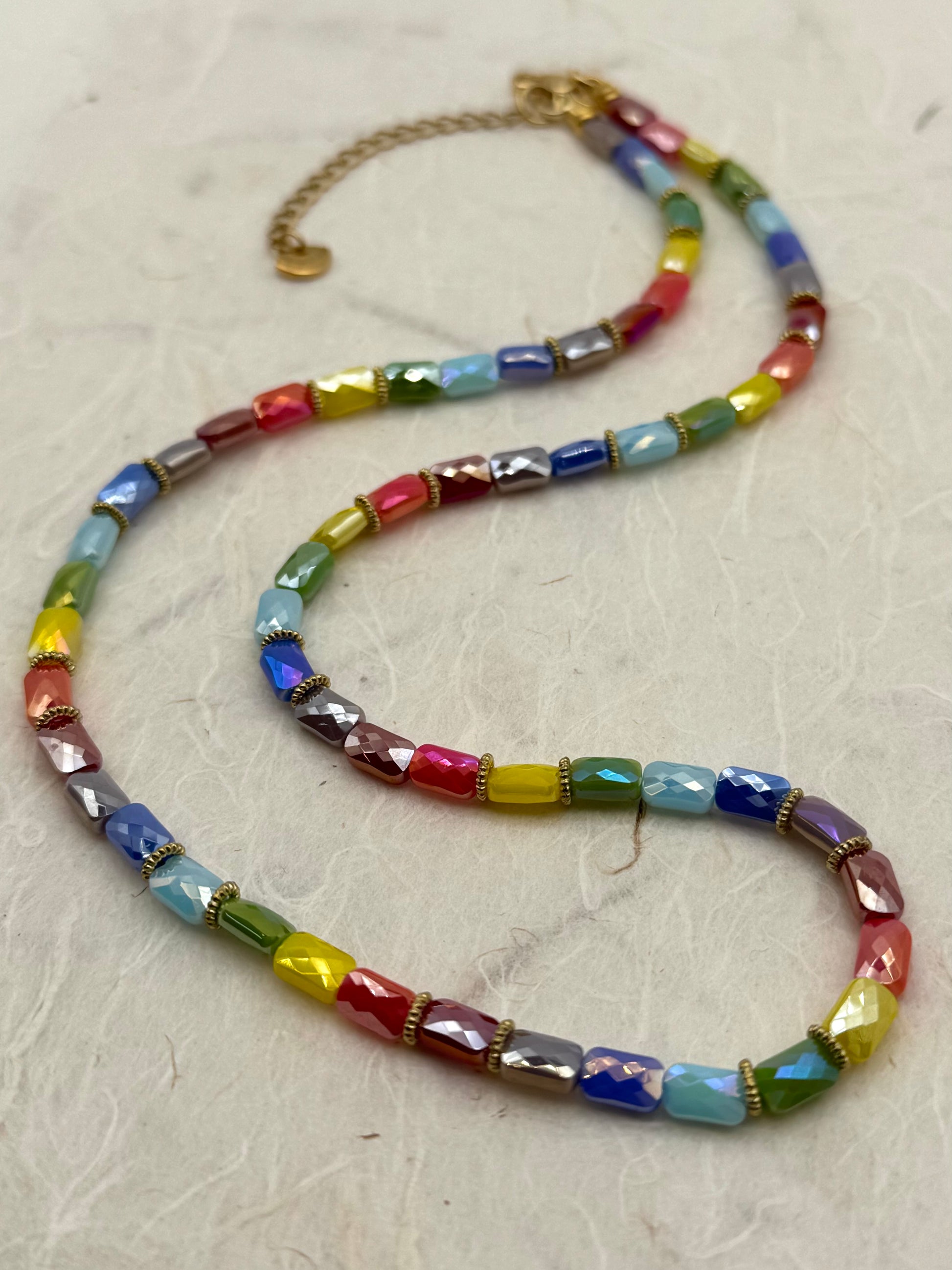 Colorful beaded necklace on a light gray surface