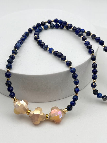 Necklace with blue beads and gold accents on a white background