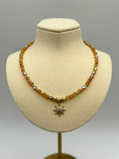 Necklace with a sun pendant on a mannequin bust against a gray background