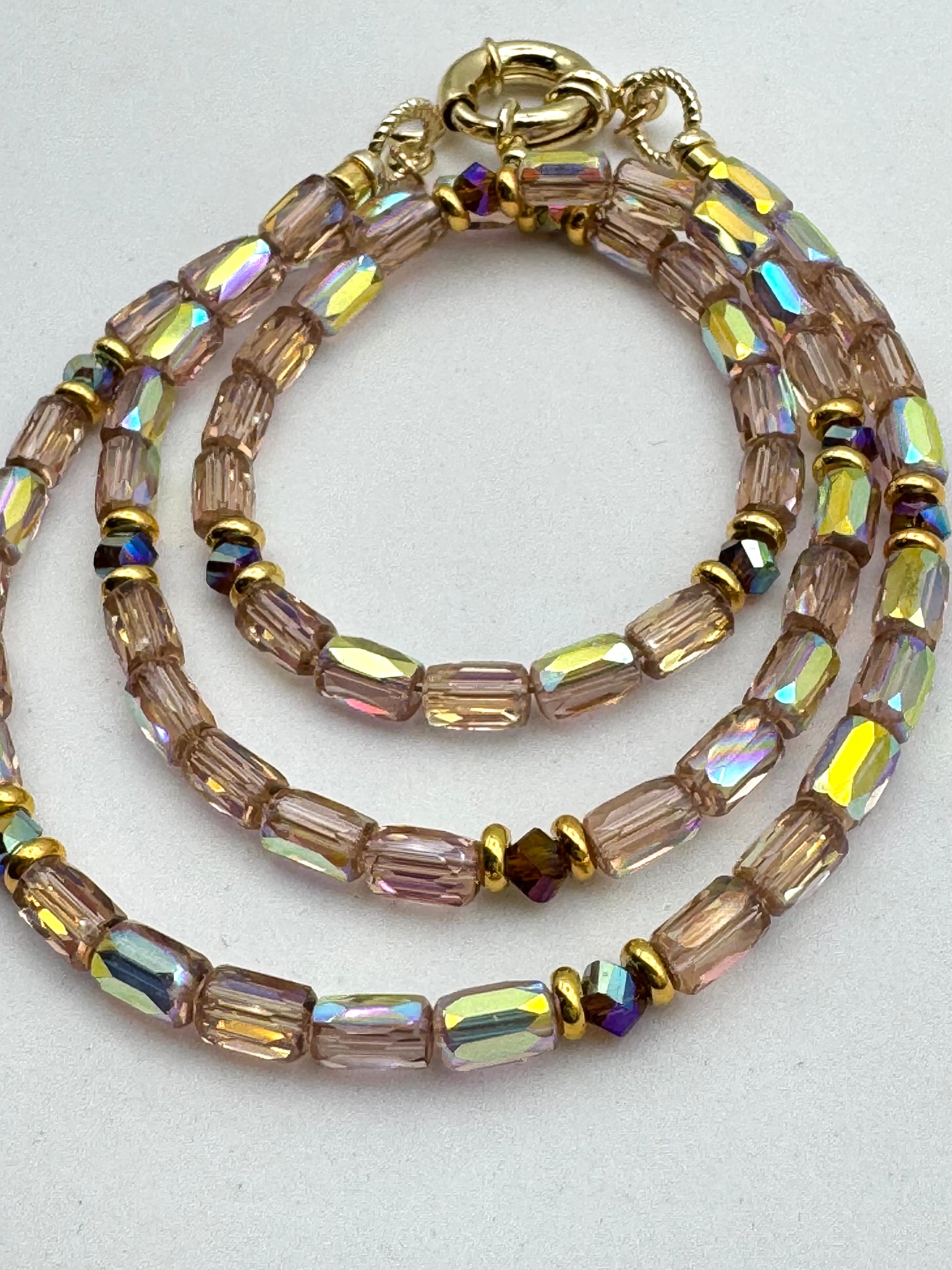Beaded bracelet with iridescent beads on a light gray background