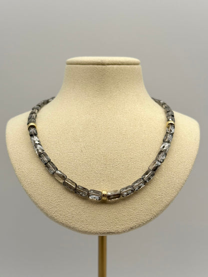 Necklace on a mannequin bust against a plain background