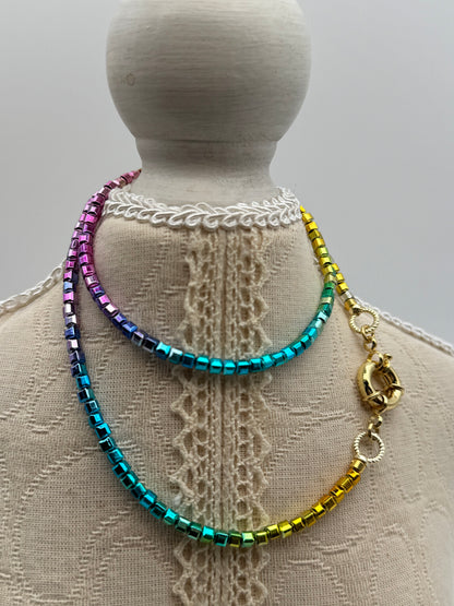 Multicolored beaded bracelet on a mannequin arm with lace background