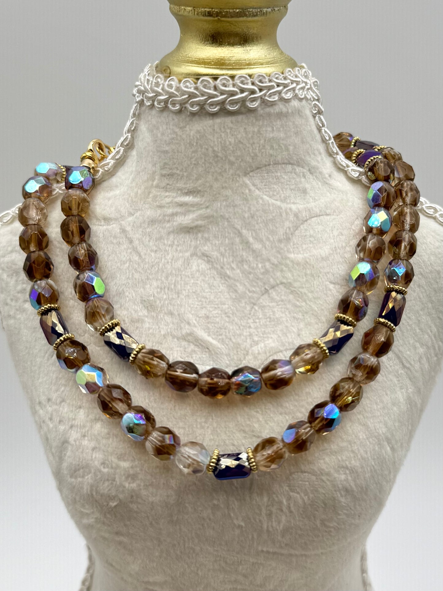 Necklace with brown and clear beads on a mannequin bust.