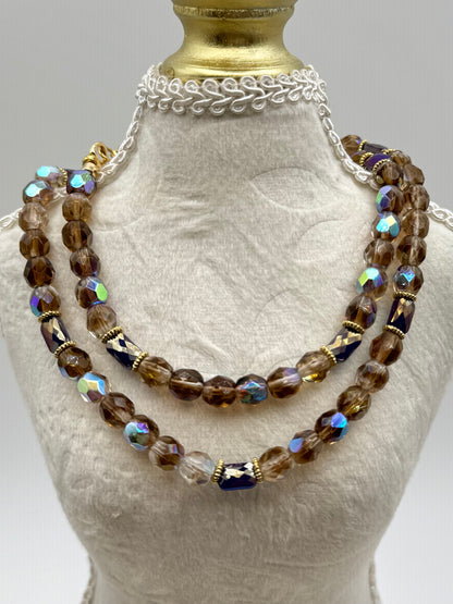 Necklace with brown and clear beads on a mannequin bust.