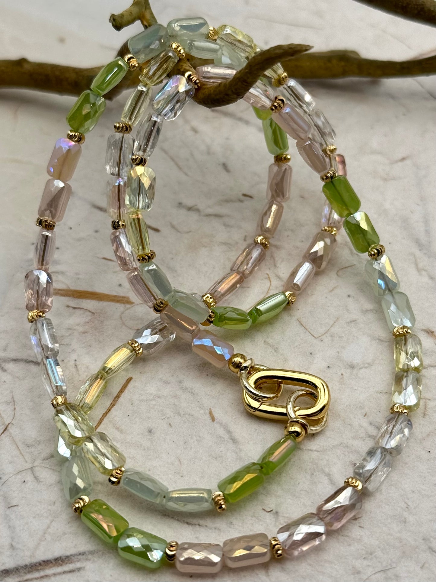 Necklace with green and clear beads on a textured surface