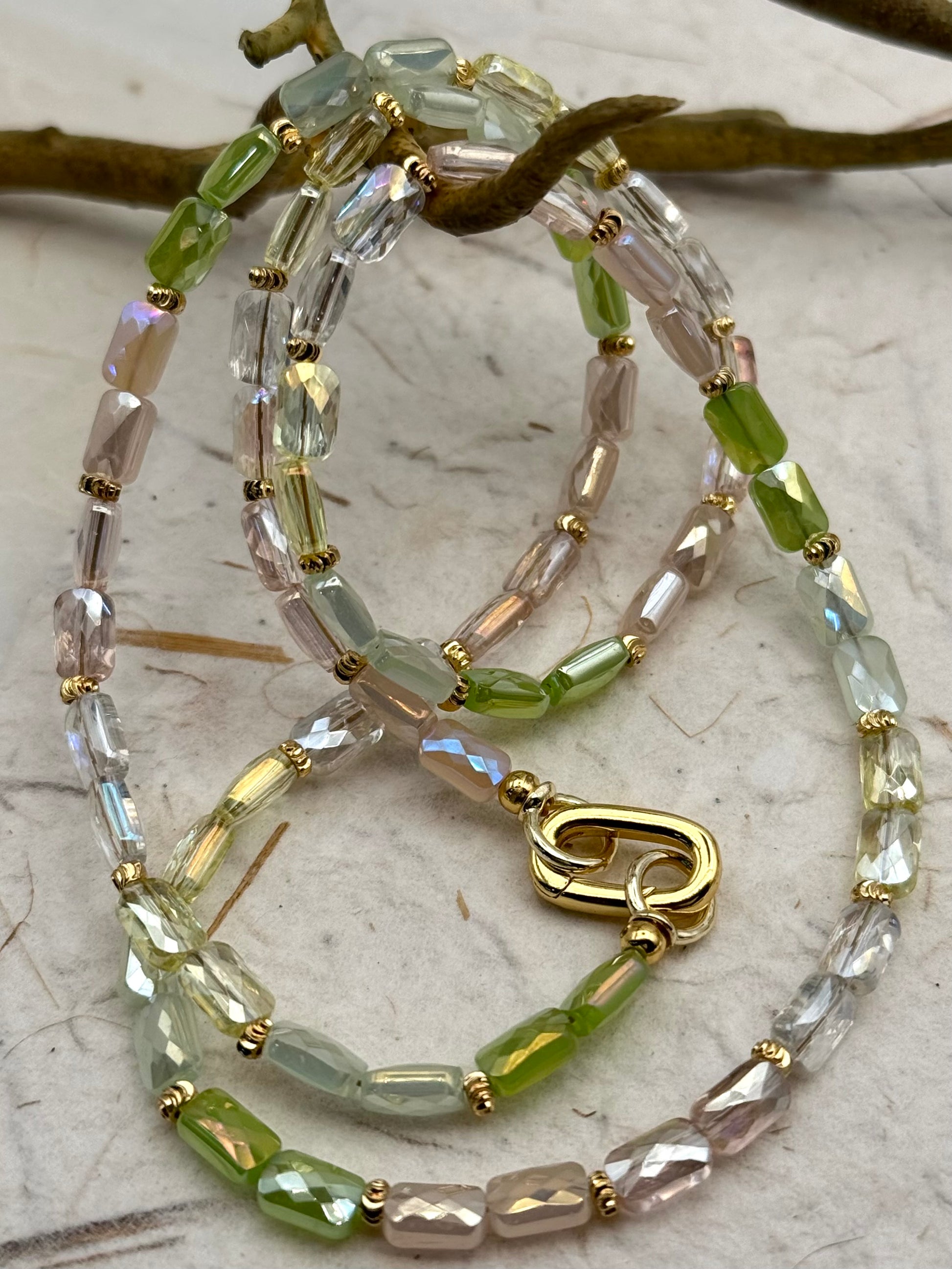 Necklace with green and clear beads on a textured surface