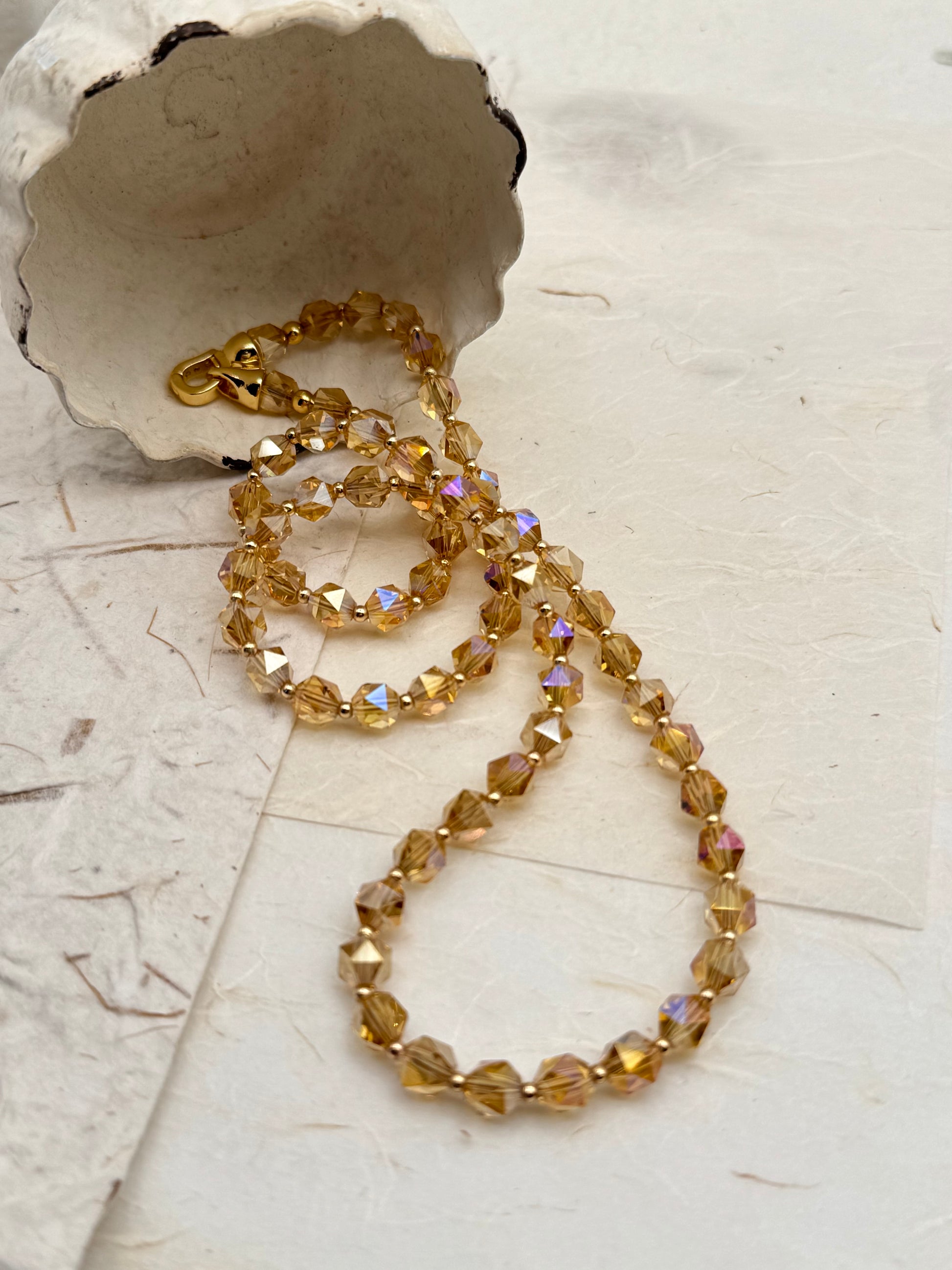 Gold beaded necklace on a textured surface