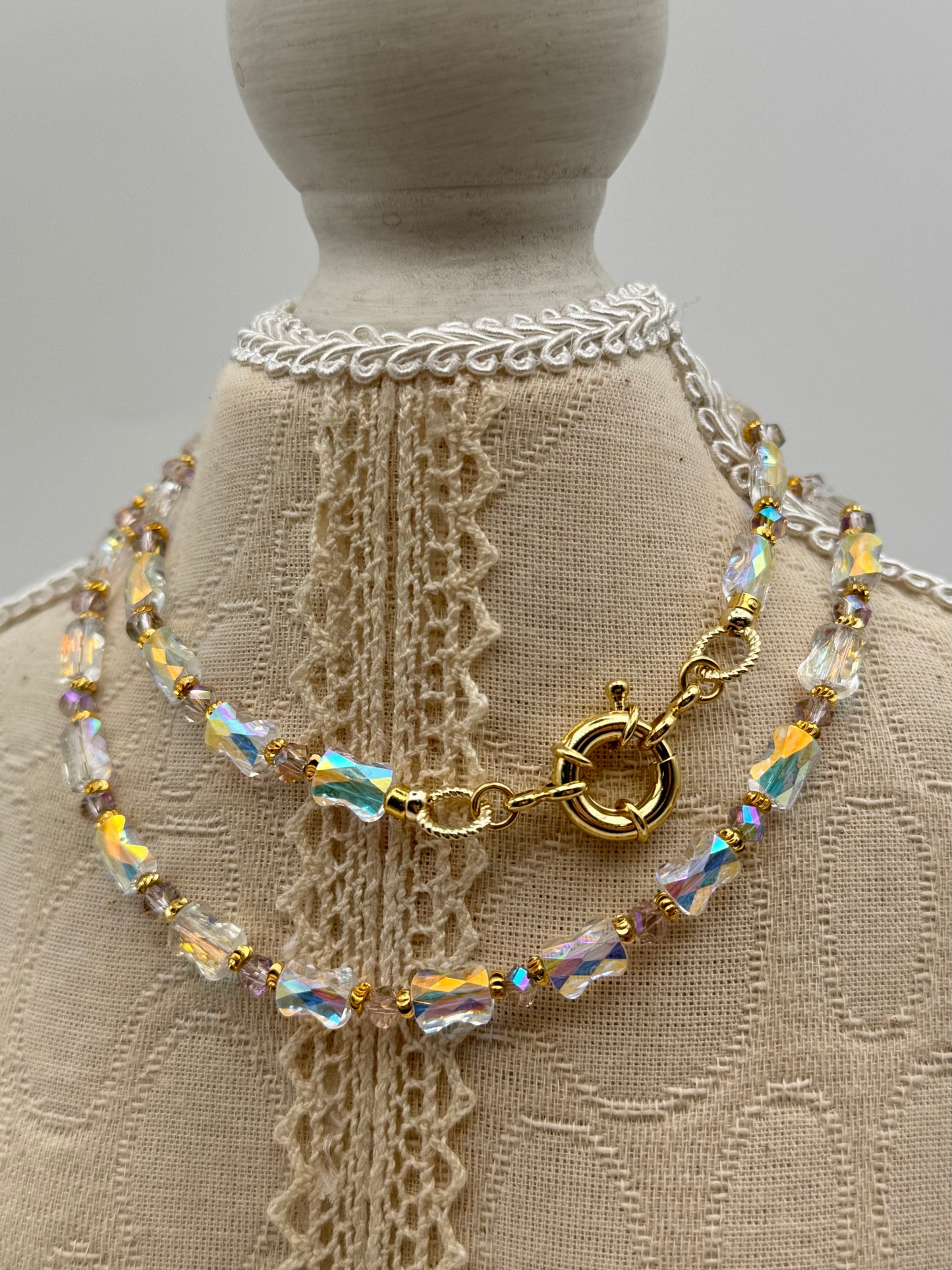 Necklace with beads and clasp on a mannequin with lace background
