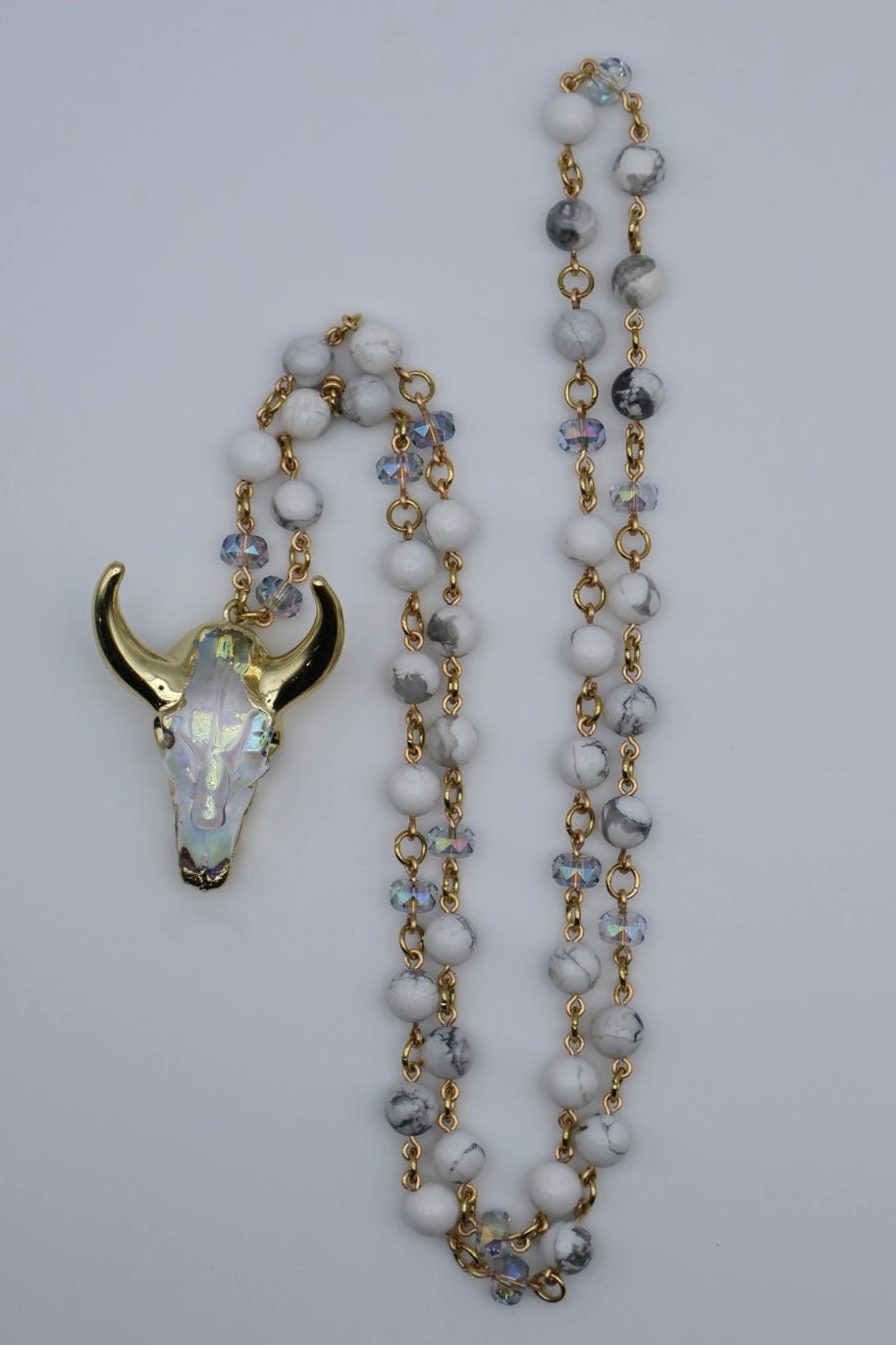 Necklace with bull skull pendant on a light gray background