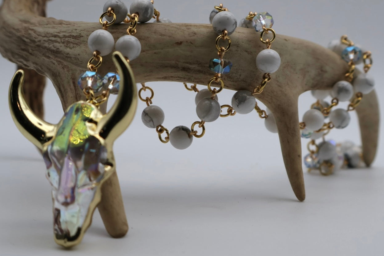 Bracelet with cow skull charm and beads on a wooden surface