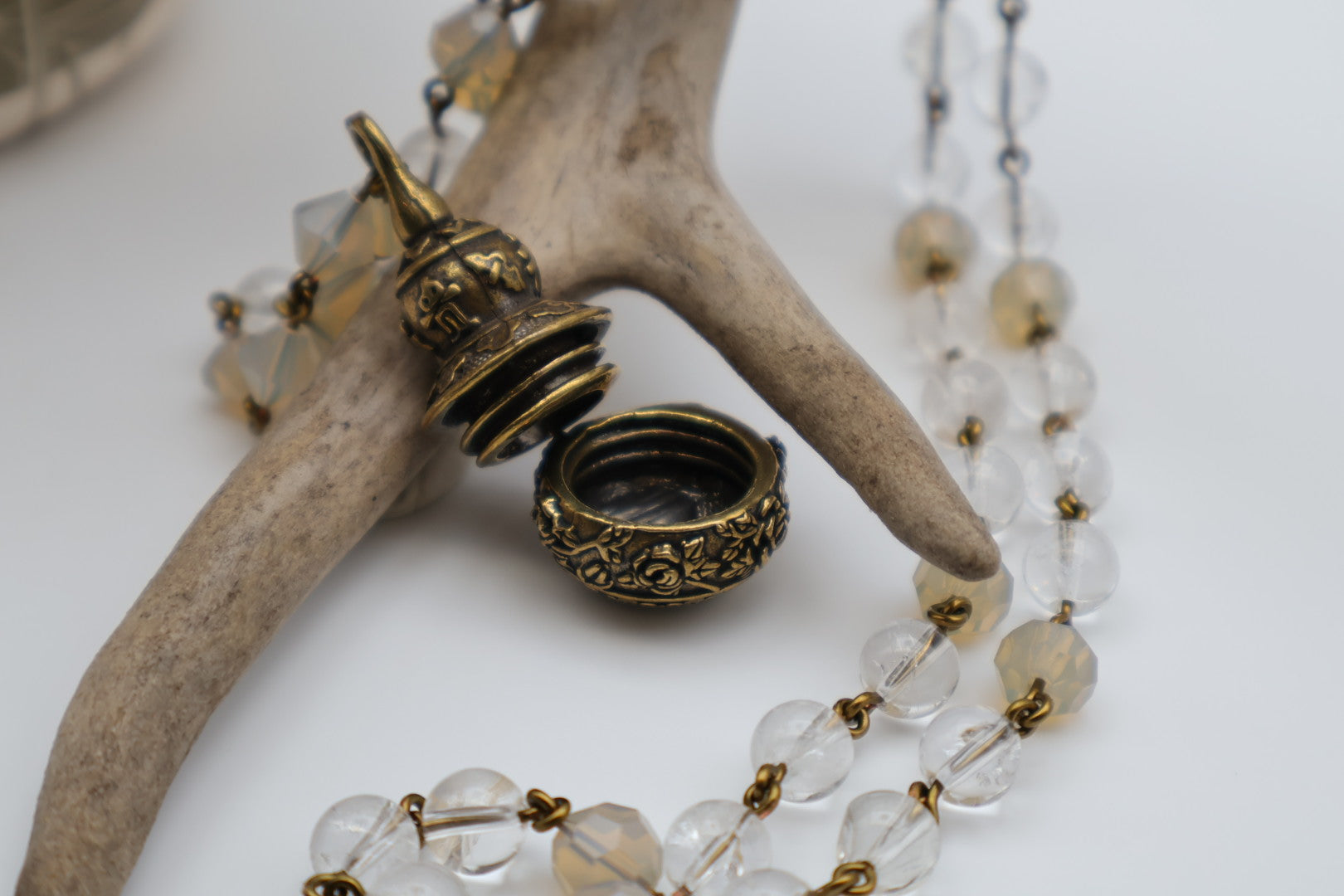 Necklace with clear beads and gold accents on a white background