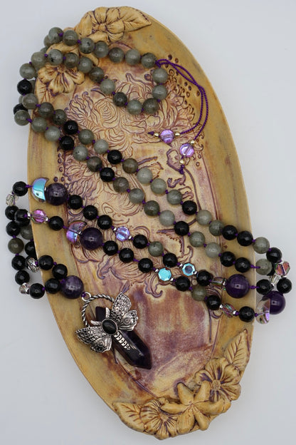 Necklace with beads and a pendant on a decorative wooden plaque