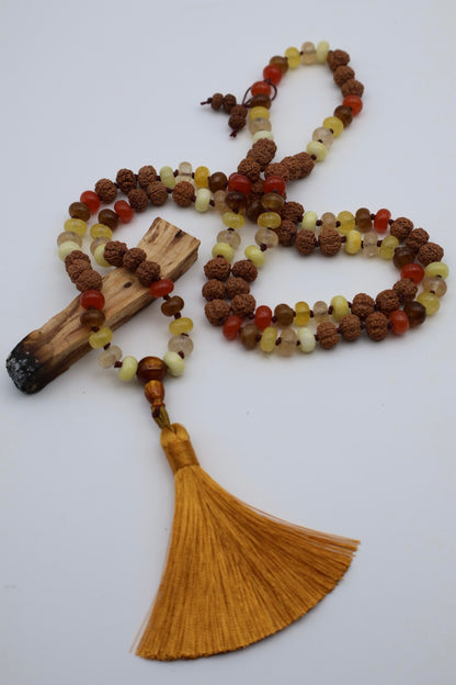 Mala necklace with beads and tassel on a white background