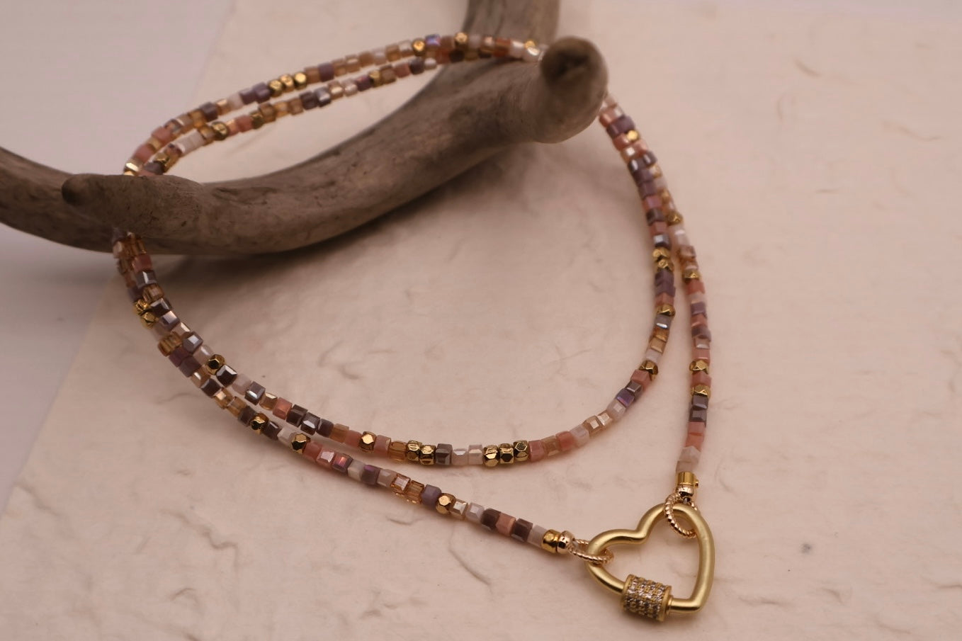 Necklace with heart clasp on a textured surface