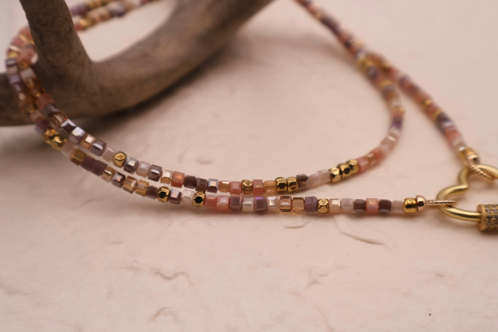 Beaded necklace with gold accents on a neutral background
