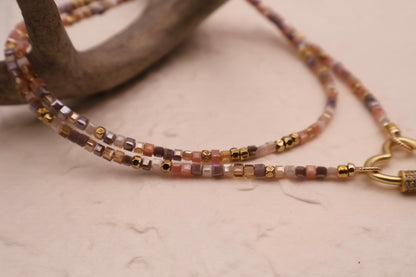 Beaded necklace with gold accents on a neutral background