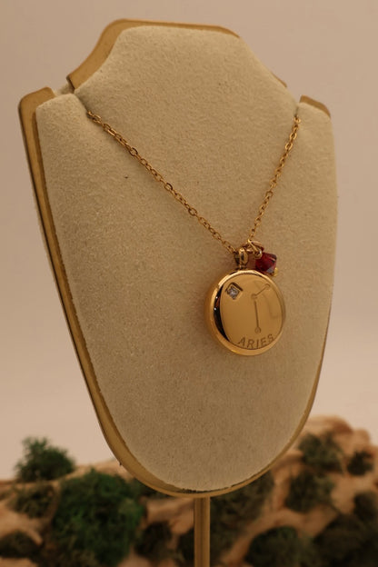 Gold necklace with a pendant on a beige bust against a blurred natural background