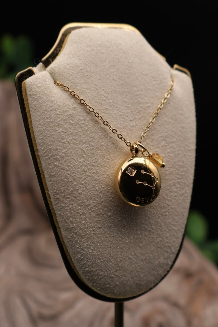 Gold necklace with a pendant on a gray bust