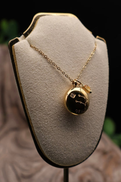 Gold necklace with a pendant on a gray bust