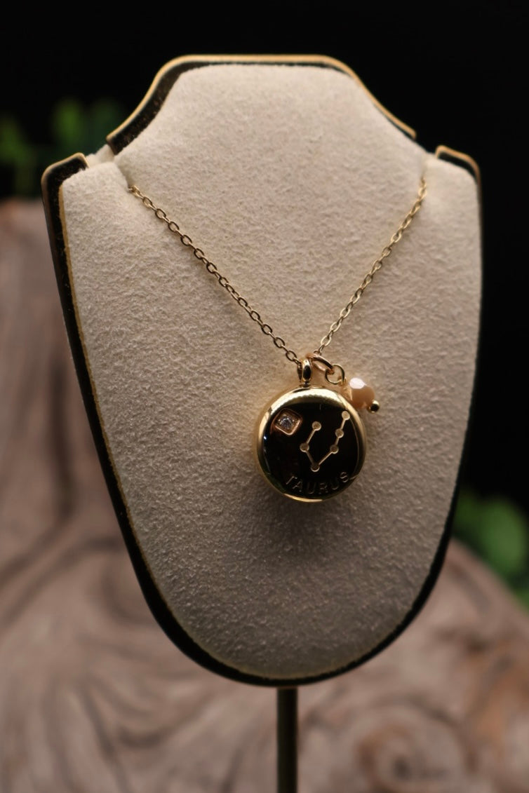 Gold necklace with a pendant on a white bust