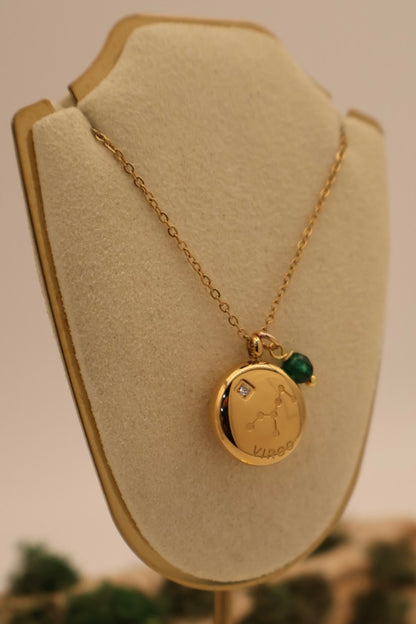 Gold necklace with a pendant on a beige bust