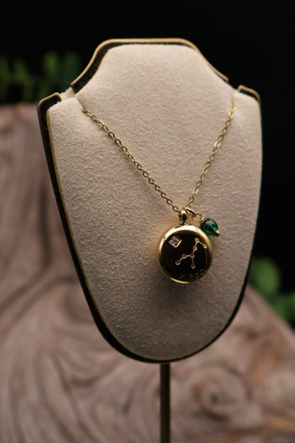 Gold necklace with a pendant on a beige bust against a blurred background