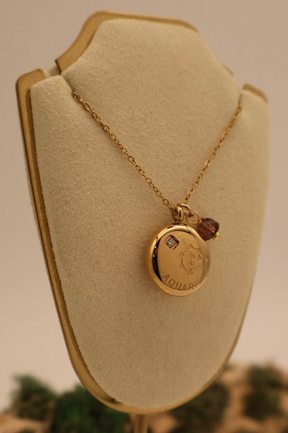 Gold necklace with a pendant on a beige jewelry display