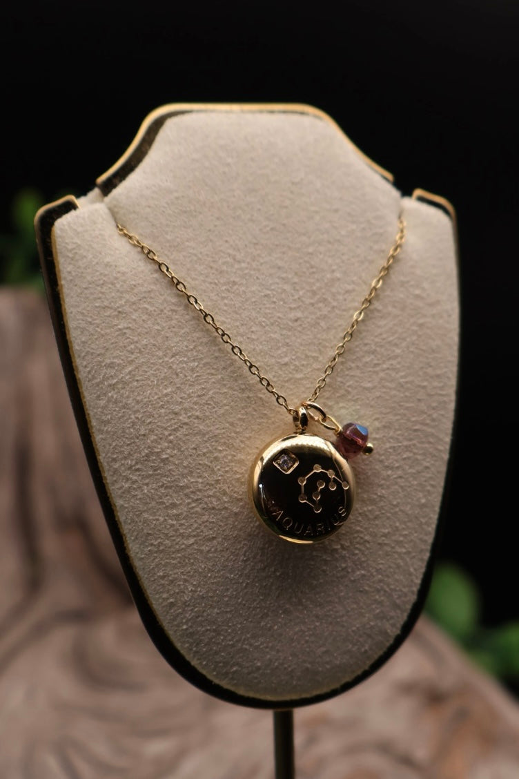 Gold necklace with a pendant on a white bust against a dark background