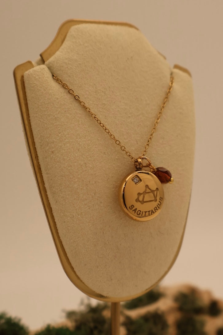 Gold necklace with a pendant on a beige bust